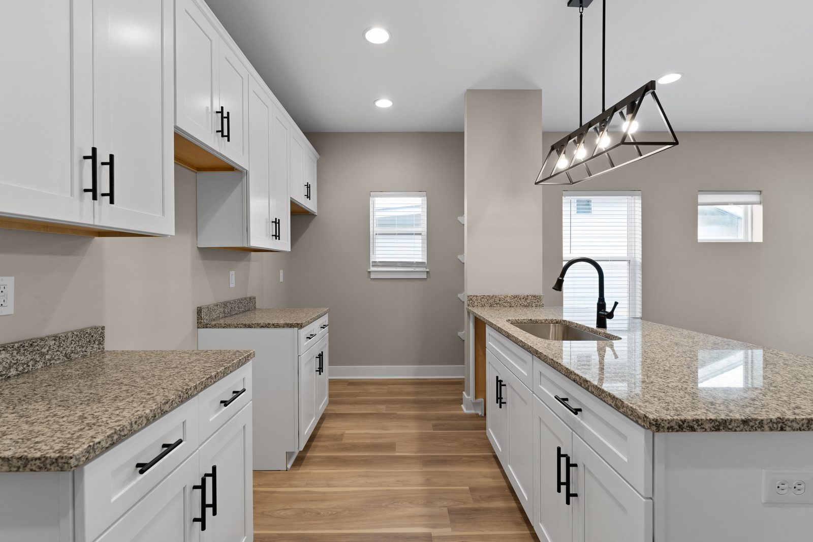 Kitchen with black hardware and iron pendant