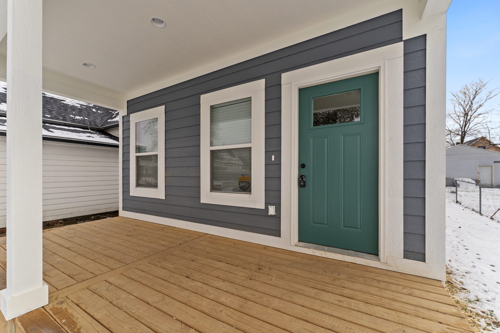 Teal front door on the porch