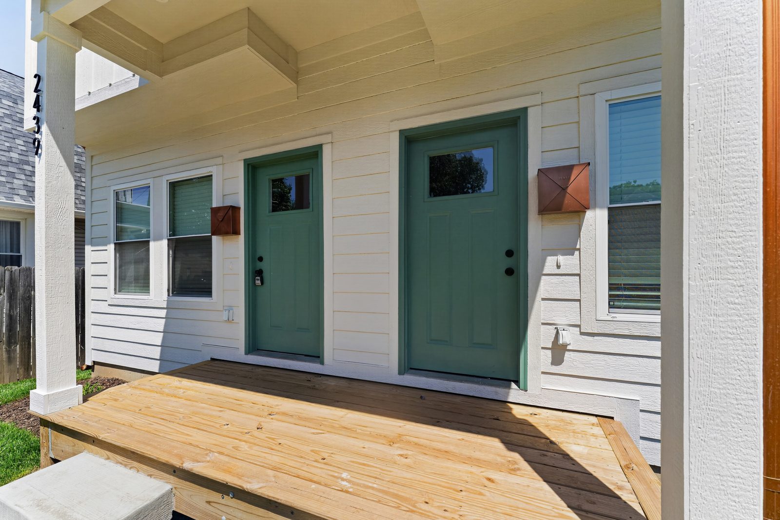 Twin green front doors on the new porch