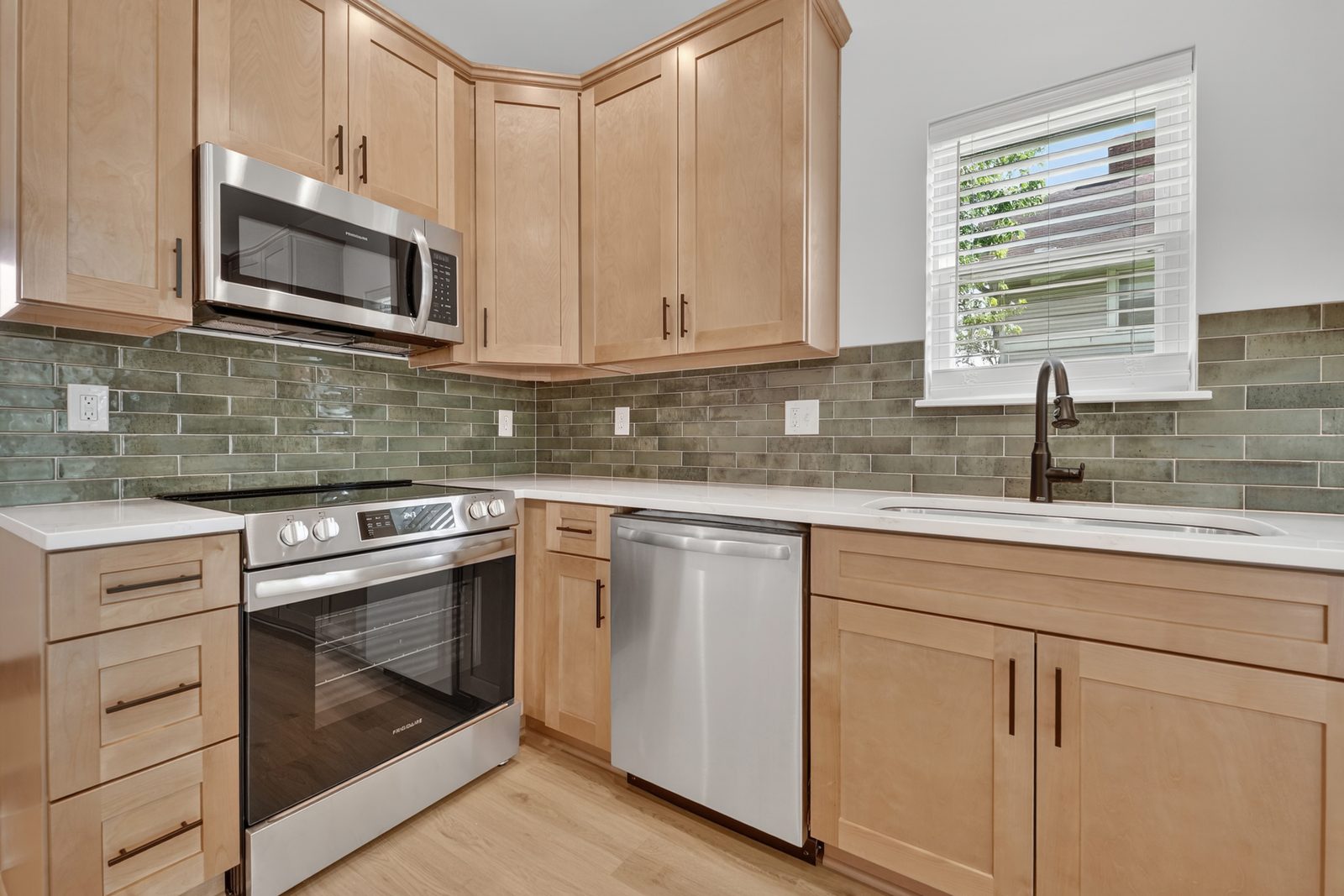 Maple cabinets with a green subway tile backsplash
