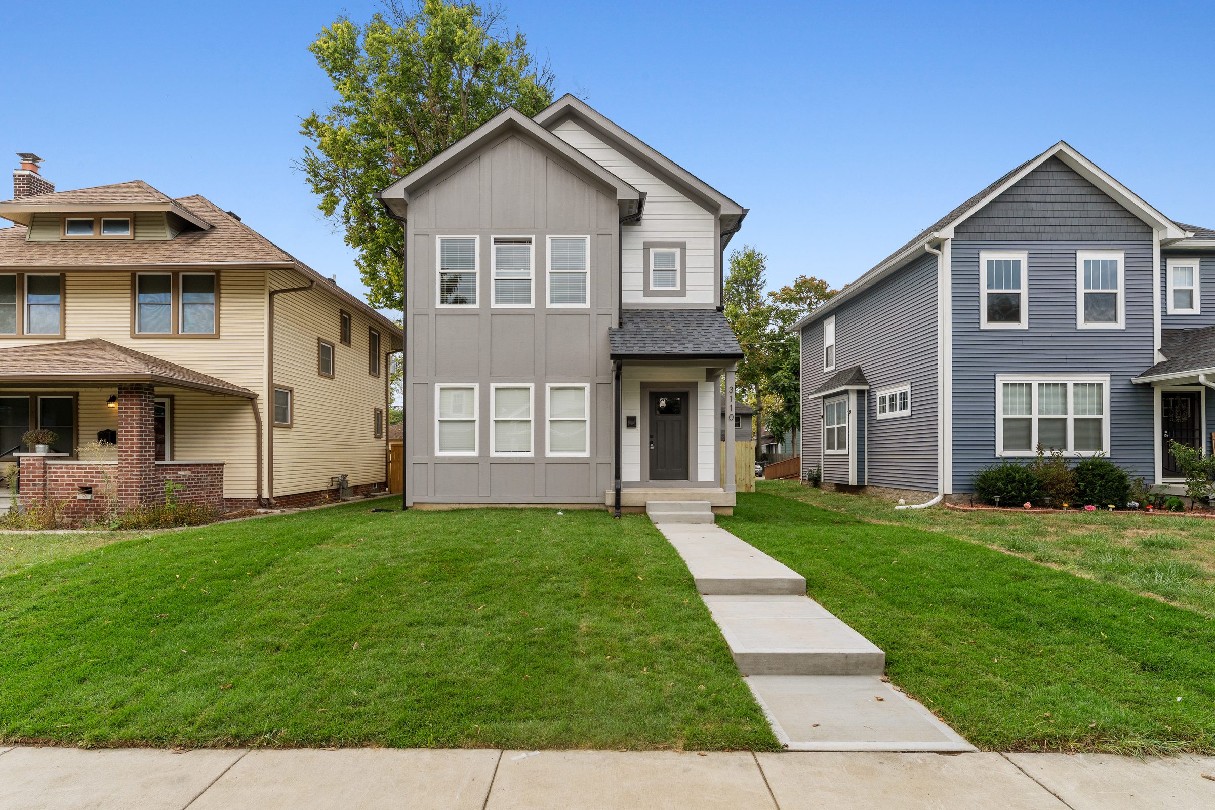 Modern gray home between two older neighbors