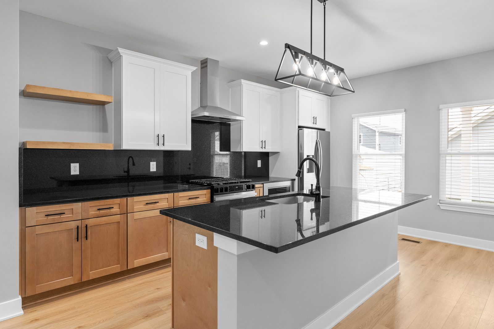 Island kitchen with black granite and floating shelves