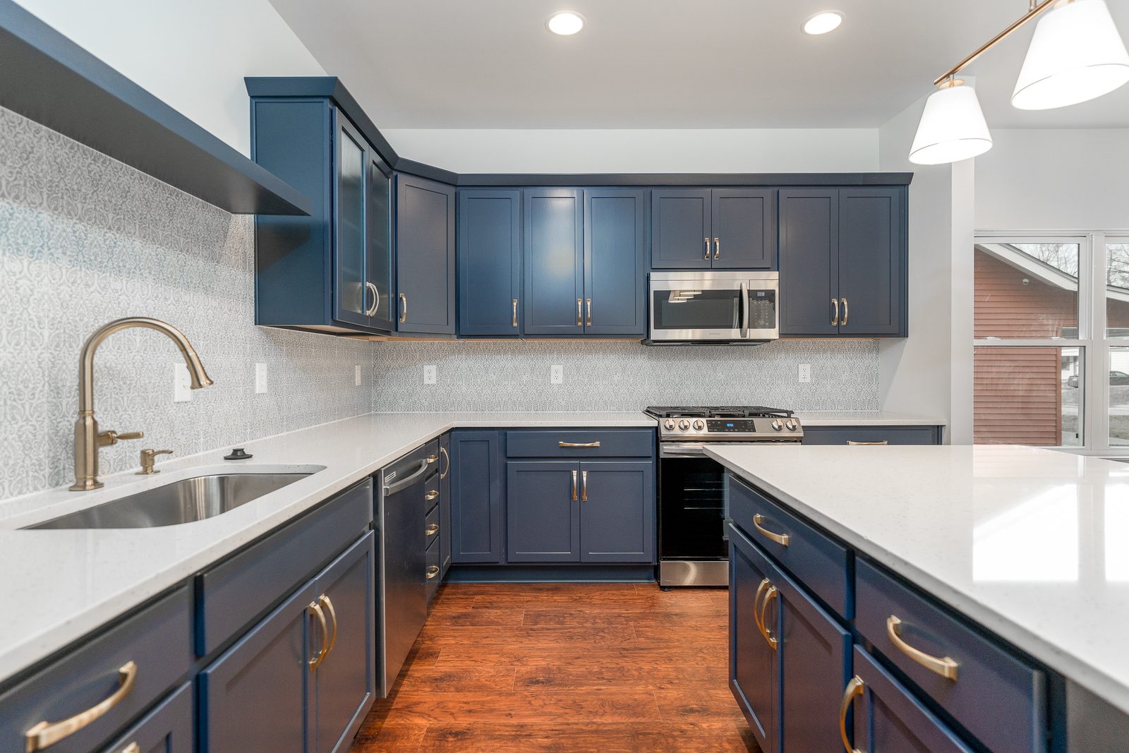 Navy cabinets, brass pulls and patterned backsplash