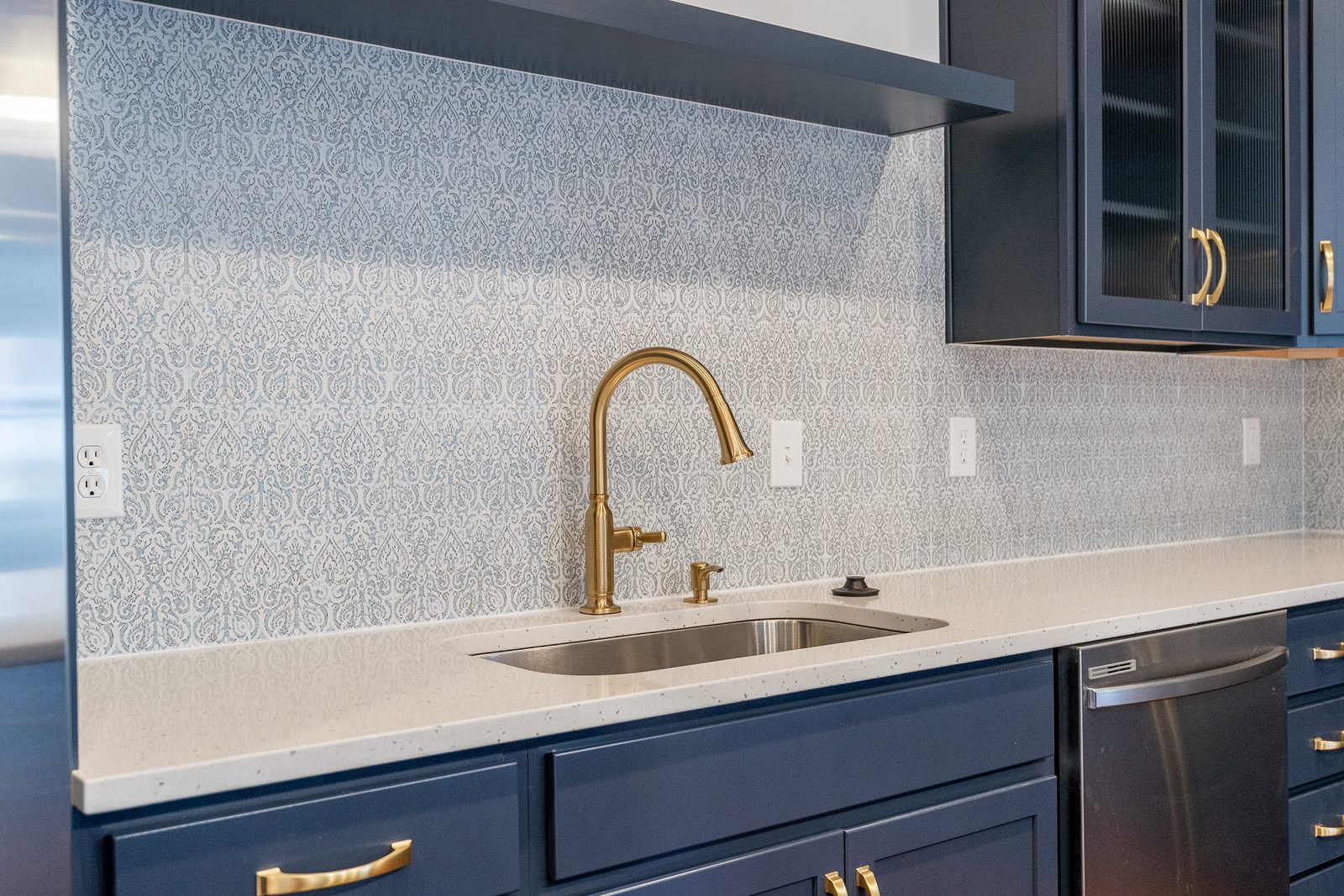Brass faucet against patterned tile