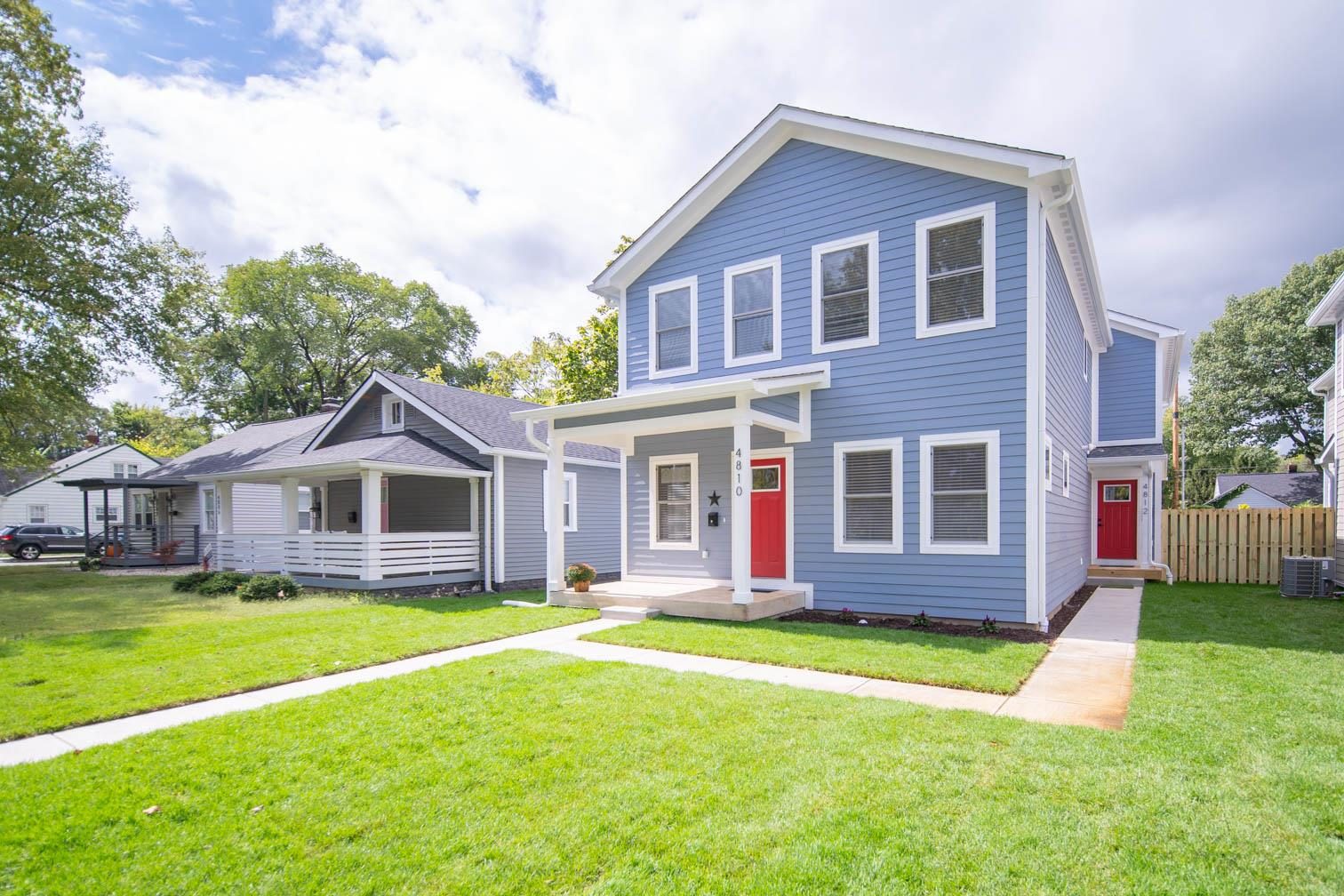 Blue home with a red door and covered porch