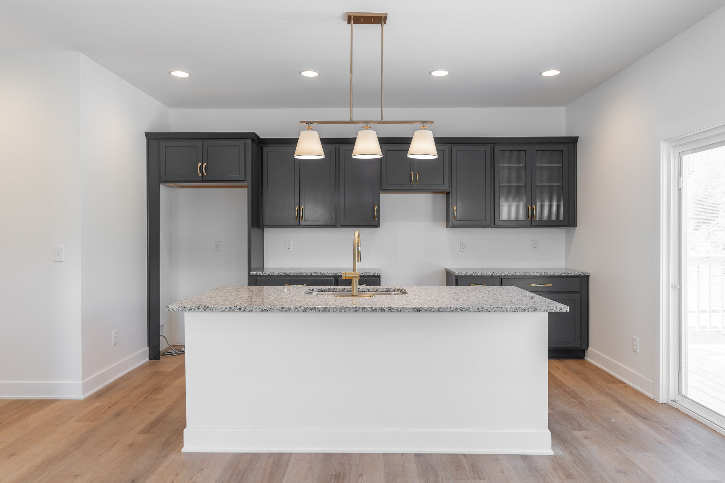 Black and brass kitchen with a granite island
