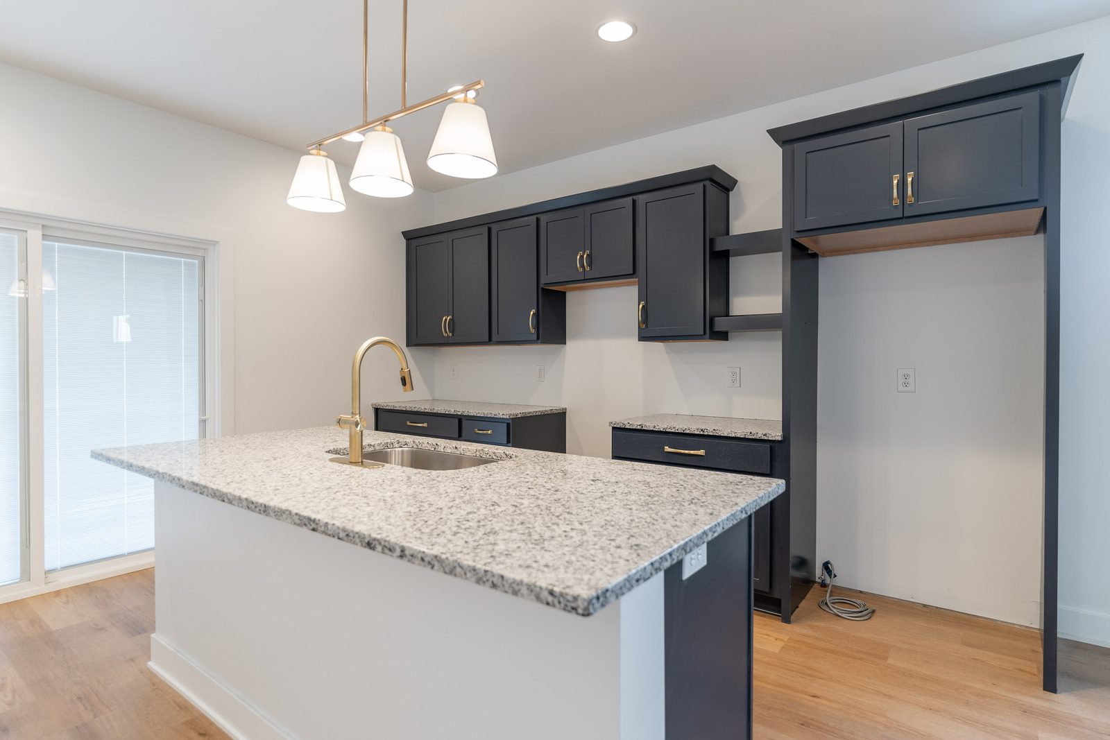Island with brass pendants and gold faucet